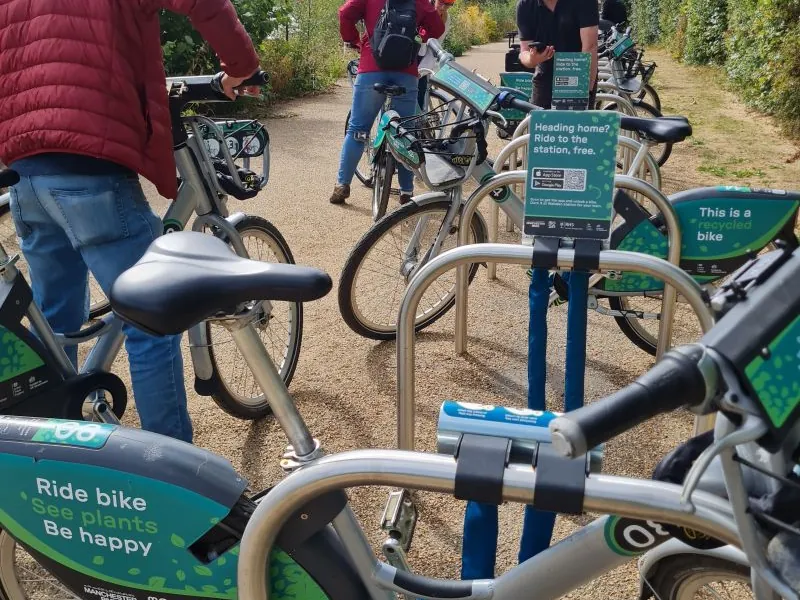 Riders unlocking shared bikes from Mosa docks on the path at RHS Bridgewater.
