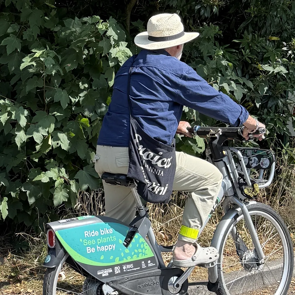 A rider in a sun hat on one of the RHS Bridgewater shared bikes.