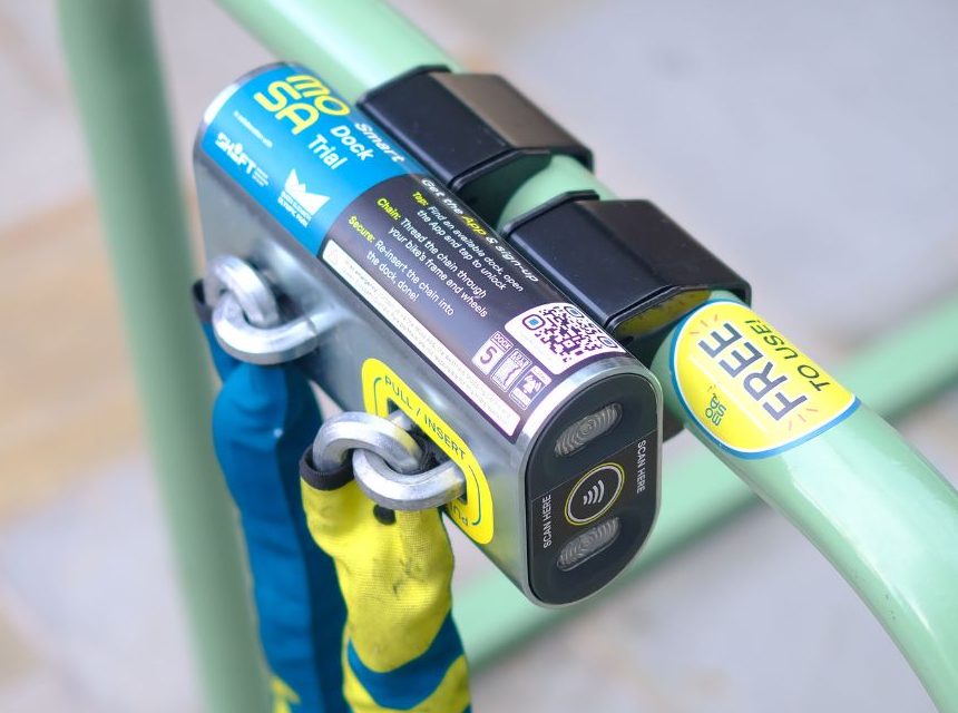 A Mosa dock clamped onto an existing green cycle rack